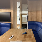 Wohnzimmer mit Blick zum TV und Richtung Küche